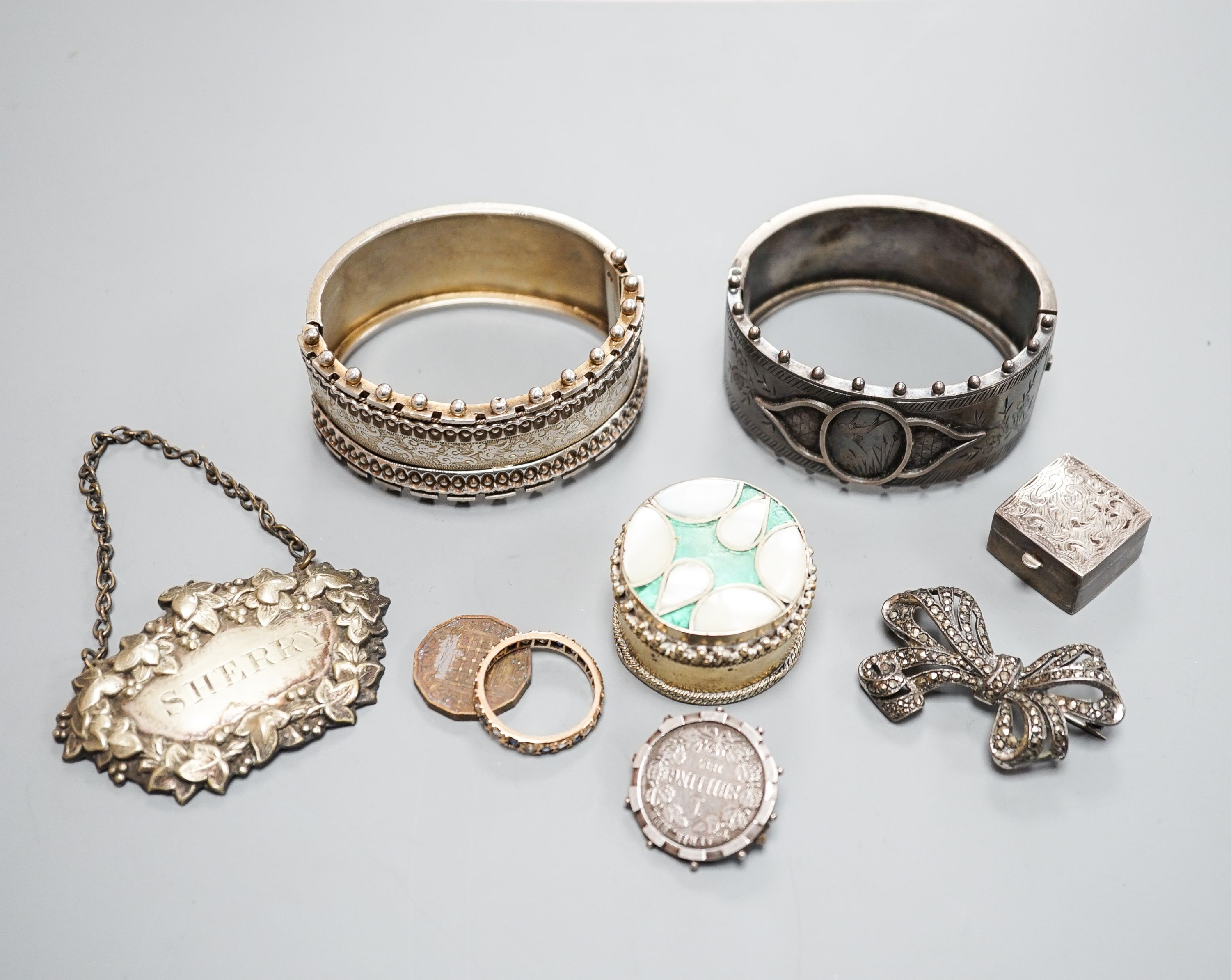Two white metal bangles including sterling, a marcasite brooch, gem set yellow metal ring and other minor items.